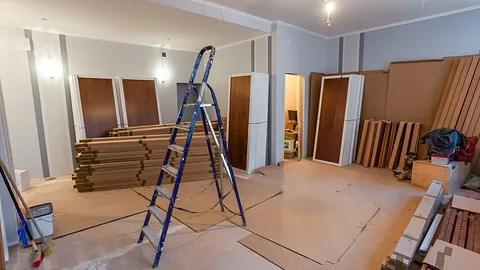Rom under rehabilitering, med nye dører og materialer stablet på gulvet